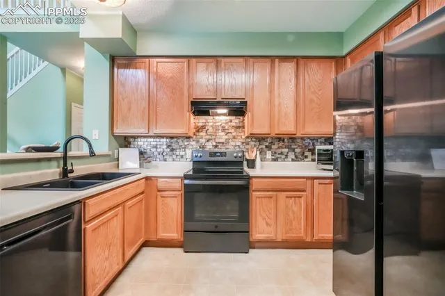a kitchen with stainless steel appliances granite countertop white cabinets and a refrigerator