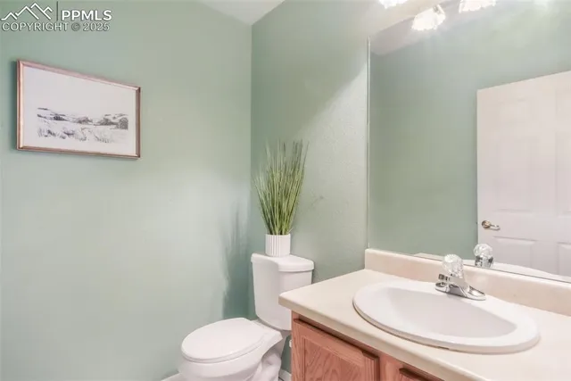 a bathroom with a sink mirror and a toilet