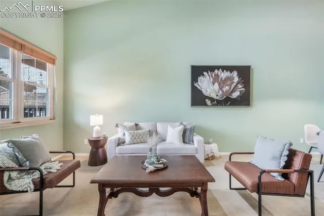 a living room with furniture and paintings on the wall