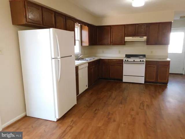 a kitchen with a refrigerator and a stove top oven