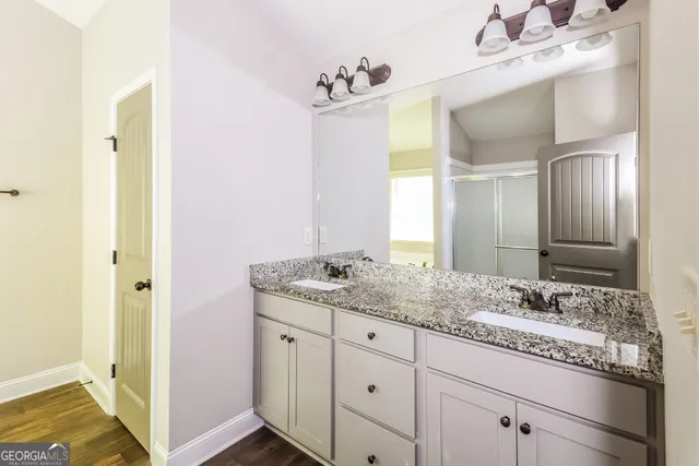a bathroom with a granite countertop sink and a mirror