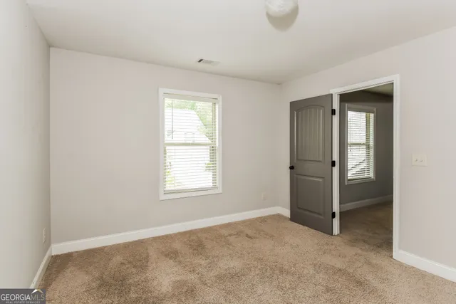 an empty room with windows and closet