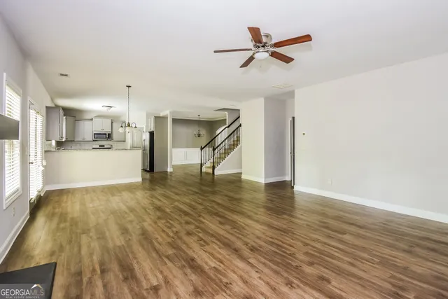 a view of a kitchen with wooden floor and a ceiling fan