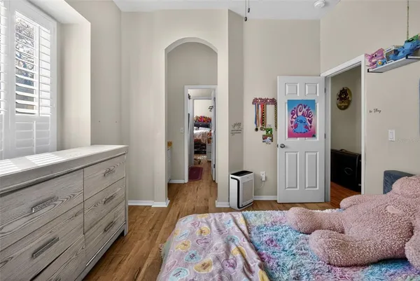 a spacious bedroom with a bed and a dresser in it