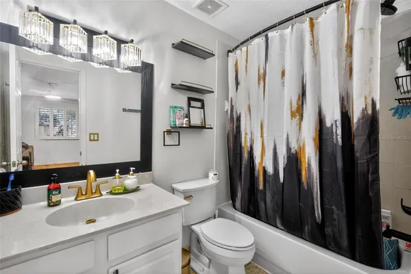 a bathroom with a sink a toilet and shower curtain