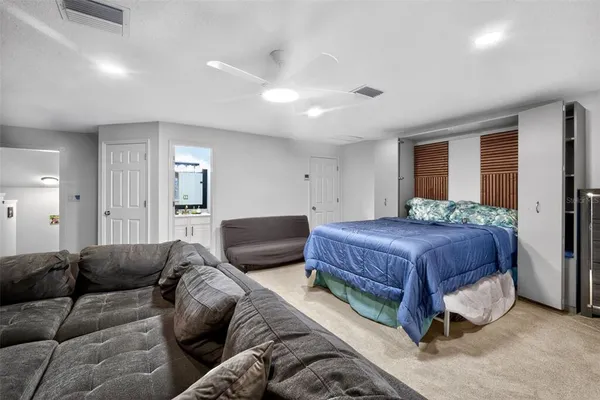 a spacious bedroom with a bed a couch and a dresser