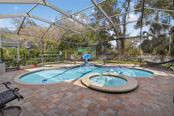 a view of a swimming pool with a patio and plants