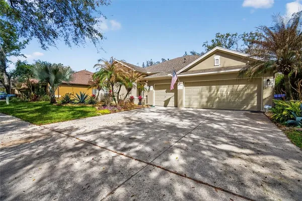 a front view of a house with a garden and trees