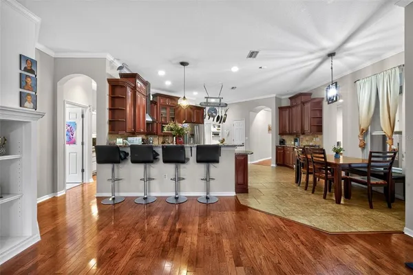 a living room with furniture kitchen view wooden floor and appliances