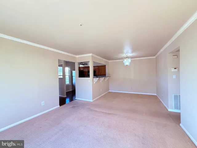 a view of a big room with wooden floor and windows