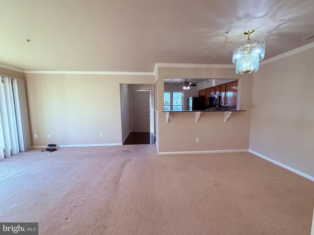 a view of a kitchen with a refrigerator a ceiling fan and a wooden floor
