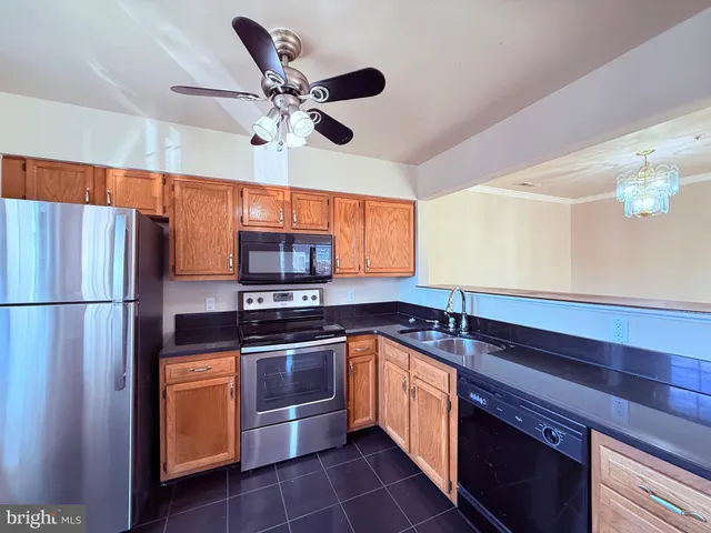 a kitchen with stainless steel appliances granite countertop a sink a stove and a refrigerator