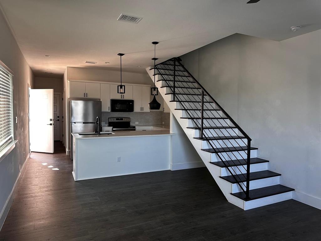21210 Portsmouth Cove, Unit A Lago Vista, TX 78645 - Photo 2 of 10 a kitchen with stainless steel appliances a refrigerator and a stove top oven