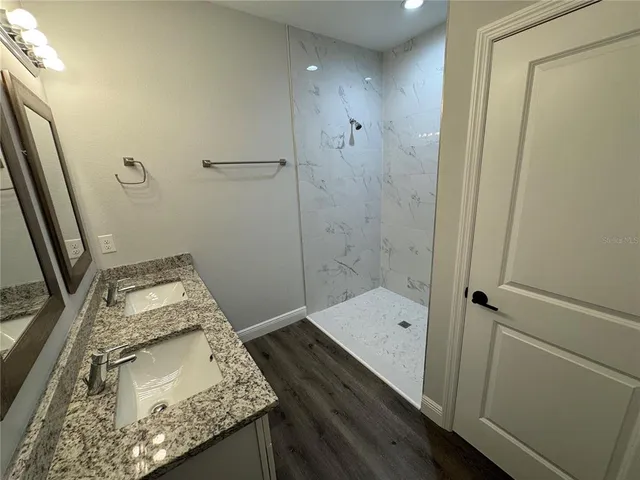 a bathroom with a granite countertop sink toilet and shower