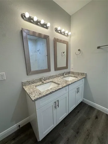 a bathroom with a granite countertop sink and a mirror