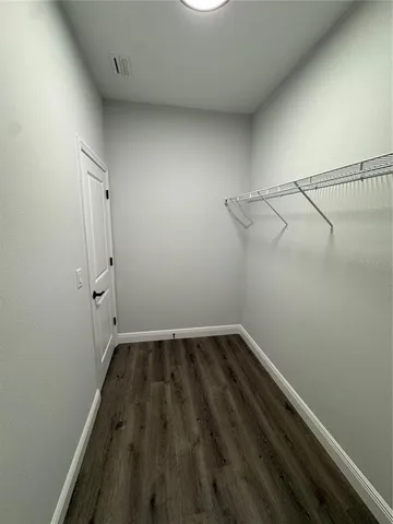 a view of a room with wooden floor and cabinets