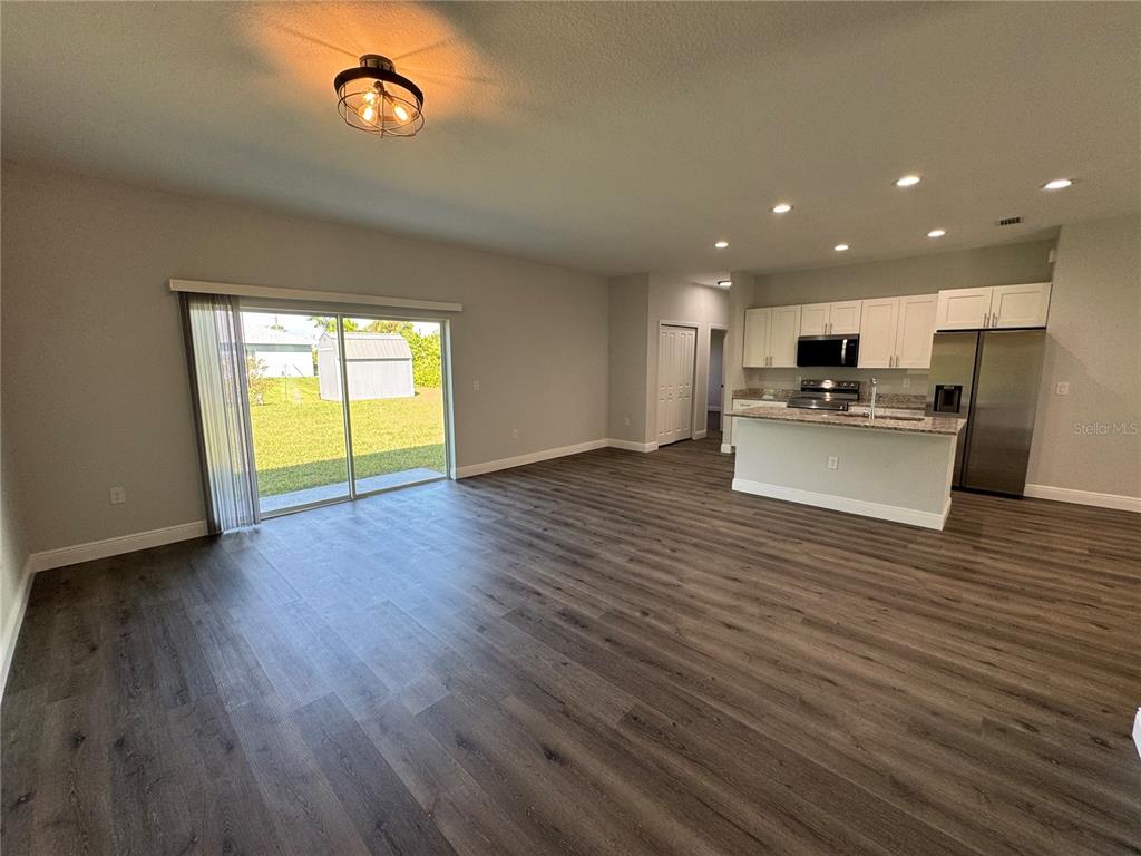 7105 Princeton Street Port Charlotte, FL 33981 - Photo 17 of 26 an open kitchen view with wooden floor and a fireplace