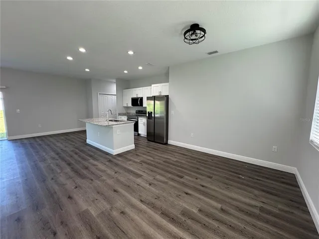 a view of a kitchen with wooden floor and an entryway
