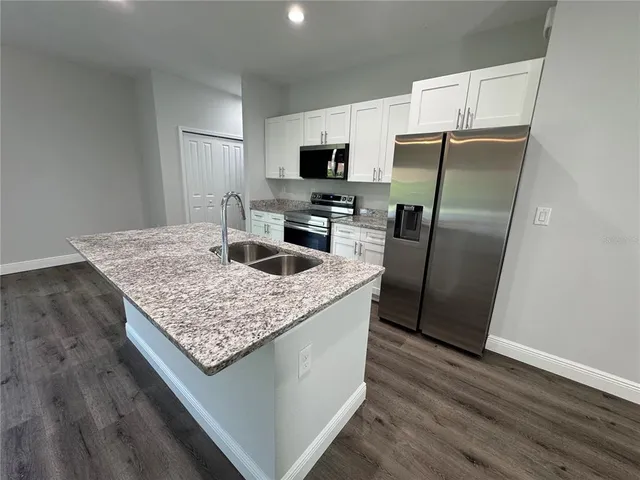 a kitchen with stainless steel appliances granite countertop a refrigerator microwave and stove