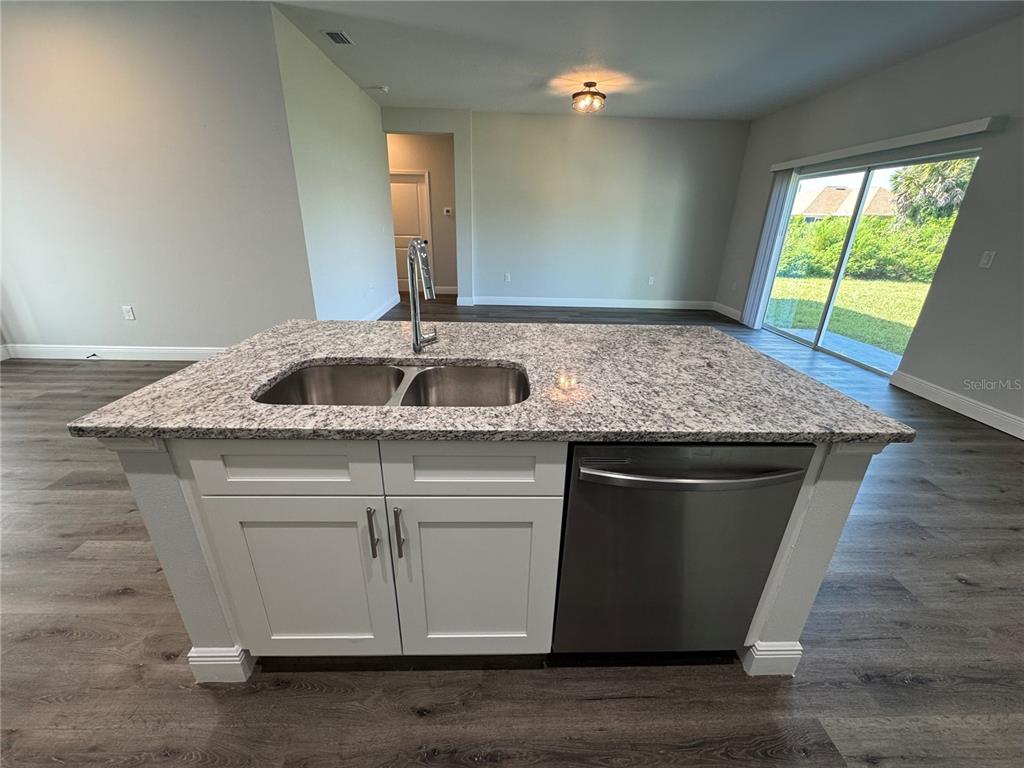 7105 Princeton Street Port Charlotte, FL 33981 - Photo 5 of 26 a kitchen with granite countertop a sink and a wooden floor