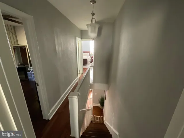 a view of a hallway with wooden floor and stairs