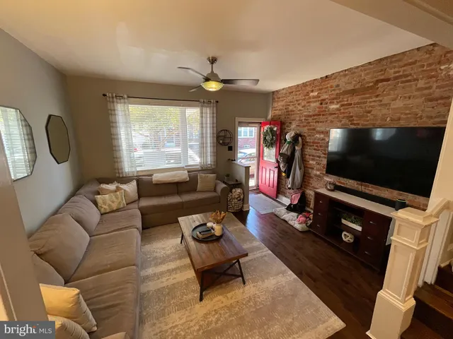 a living room with furniture a flat screen tv and a floor to ceiling window
