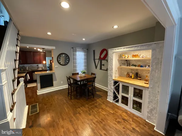a living room with furniture a flat screen tv and a refrigerator