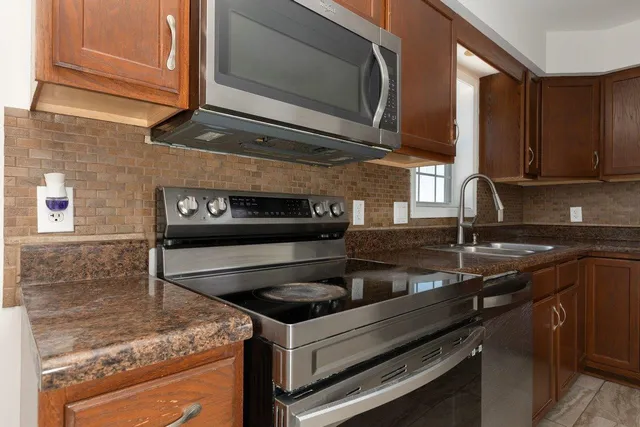 a kitchen with granite countertop a stove and a microwave