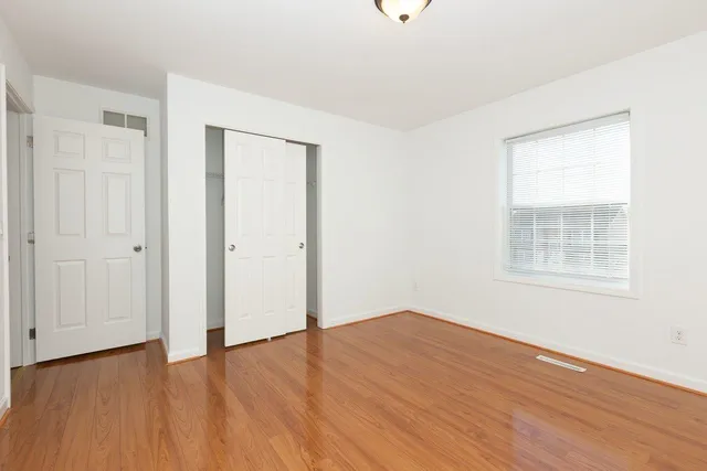 a view of an empty room with wooden floor