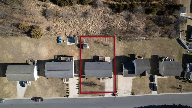 an aerial view of residential houses with outdoor space and parking