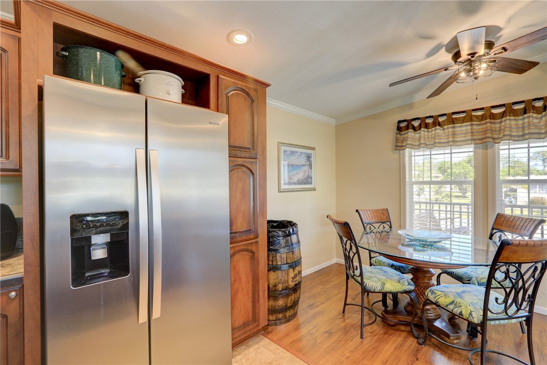 309 Pineapple Street Sebastian, FL 32958 - Photo 18 of 36 a kitchen with stainless steel appliances granite countertop a dining table chairs and a refrigerator