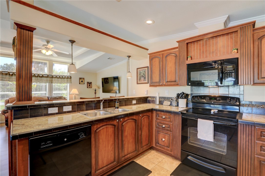 309 Pineapple Street Sebastian, FL 32958 - Photo 24 of 36 a kitchen with stainless steel appliances granite countertop a sink stove and microwave