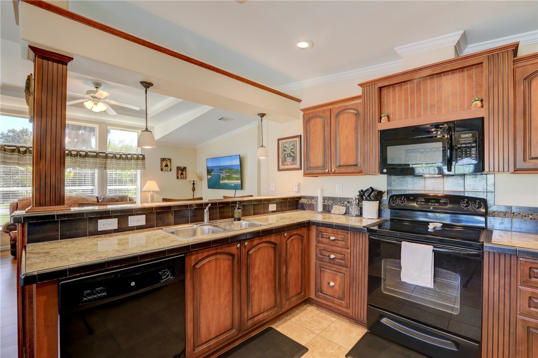 309 Pineapple Street Sebastian, FL 32958 - Photo 25 of 36 a kitchen with stainless steel appliances granite countertop a sink stove and microwave