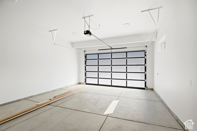 4092 Discovery Way Park City, UT 84098 - Photo 48 of 66 Spacious garage featuring a modern glass panel garage door, concrete flooring, recessed lighting, and a garage door opener