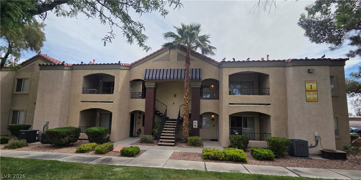 7885 West Flamingo Road, Unit 1008 Las Vegas, NV 89147 - Photo 20 of 29 A well-maintained stucco facade with balconies and a central staircase welcomes residents.