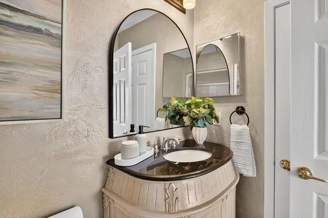 a bathroom with a granite countertop sink a toilet and shower
