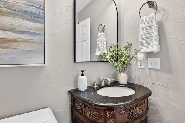 a bathroom with a granite countertop sink a toilet and shower