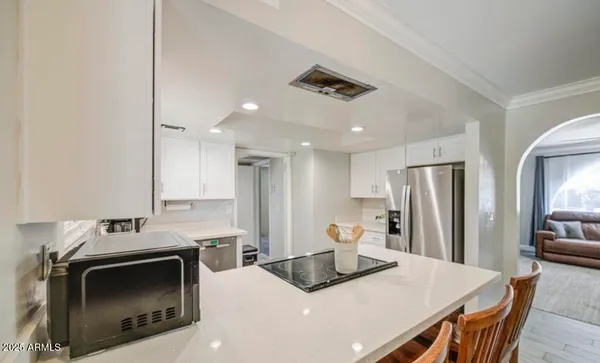 a kitchen with kitchen island a stove a refrigerator a sink a dining table and chairs