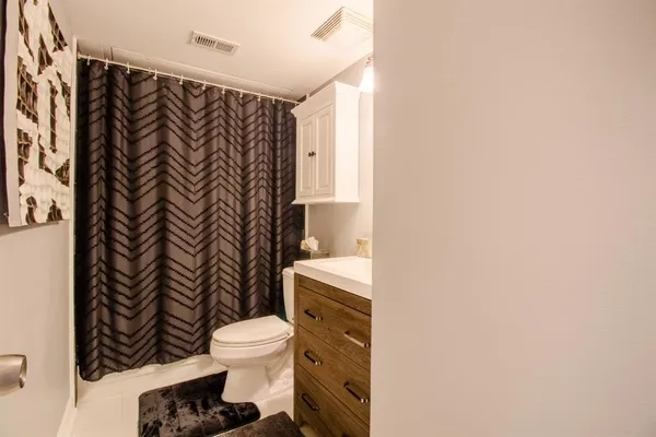 a bathroom with a toilet and a shower curtain