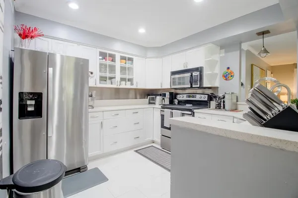 a kitchen with a refrigerator sink and cabinets