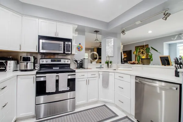 a kitchen with white cabinets stainless steel appliances and sink