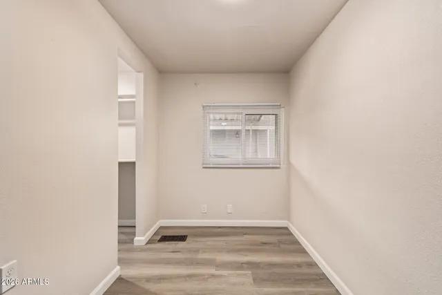 a view of an empty room with wooden floor