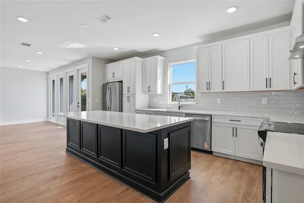 a kitchen with stainless steel appliances granite countertop a sink stove and refrigerator