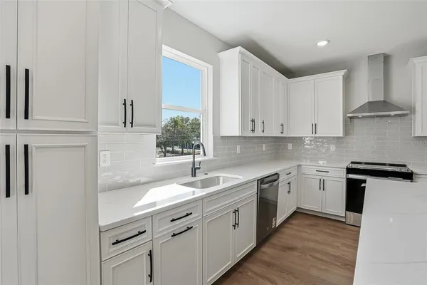 a kitchen with a sink stove and cabinets
