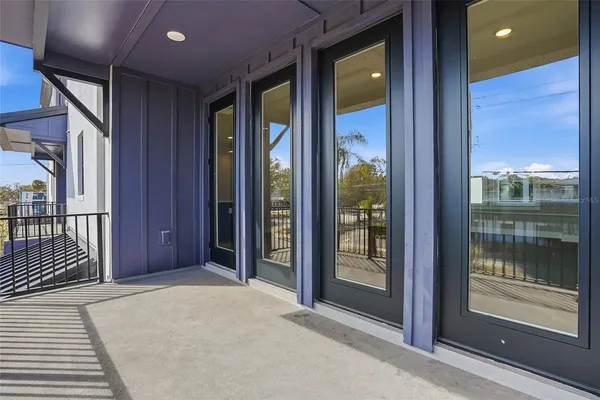 a view of a hallway with wooden floor and windows
