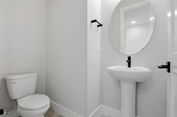 a bathroom with a toilet a sink and mirror