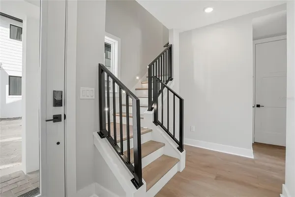 a view of a hallway with wooden floor and entryway