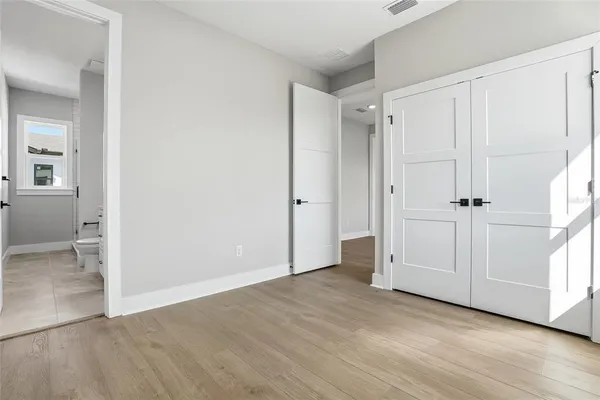 an empty room with wooden floor and white doors