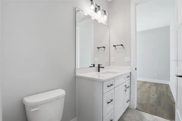 a bathroom with a toilet a sink a mirror and vanity