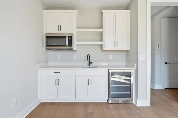 a kitchen with white cabinets and sink